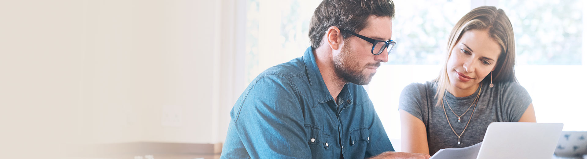 Couple looking into documents and laptop