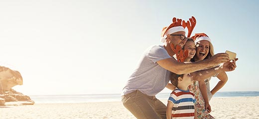 Family taking a selfie at the beach on Christmas