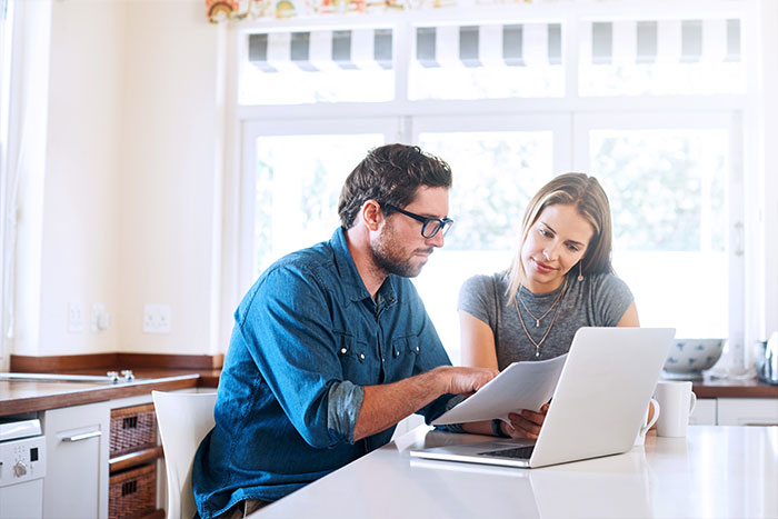 Couple looking into documents and laptop.